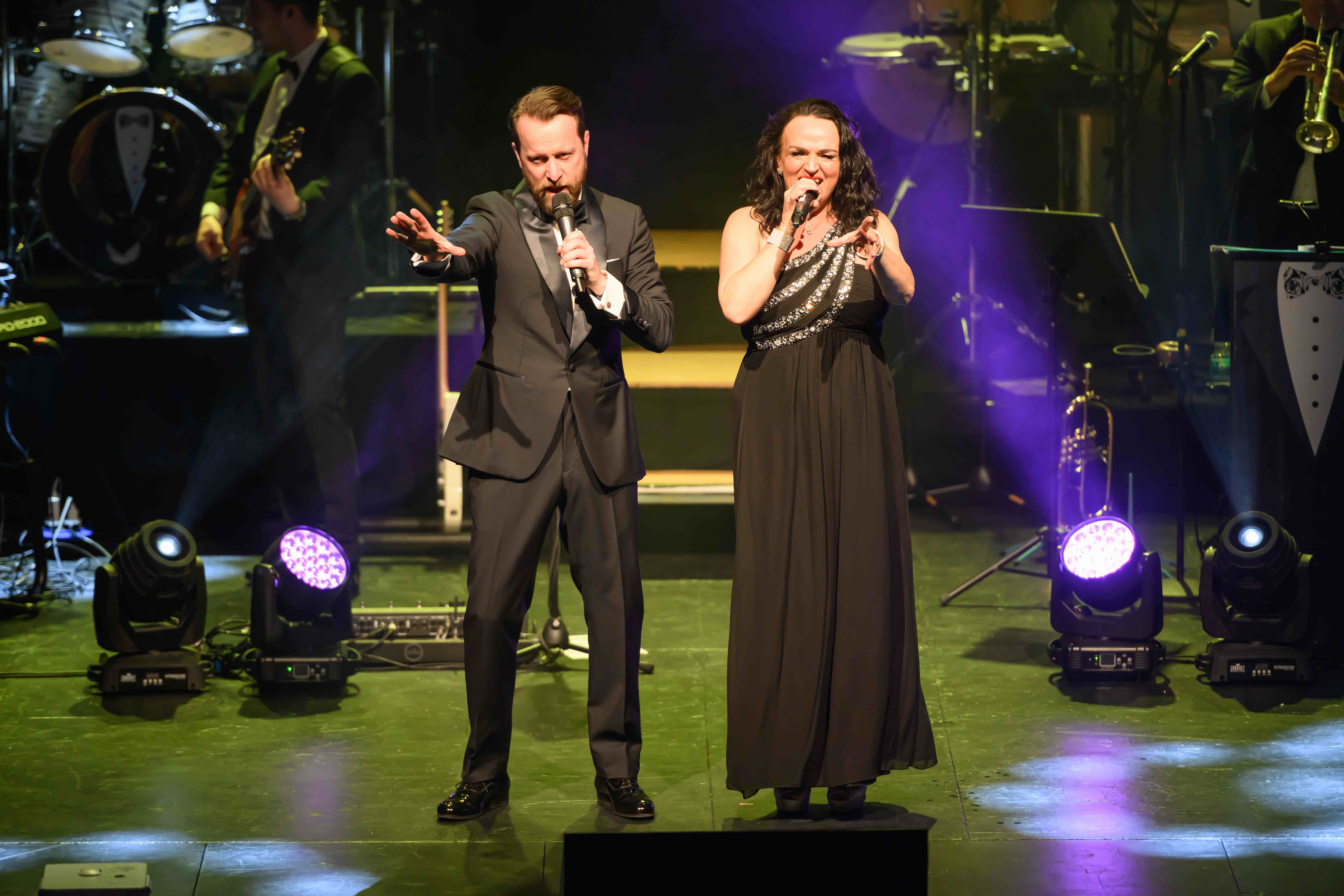 James Bond Themed Concert Spectacular featuring singers and a band on a theatre stage