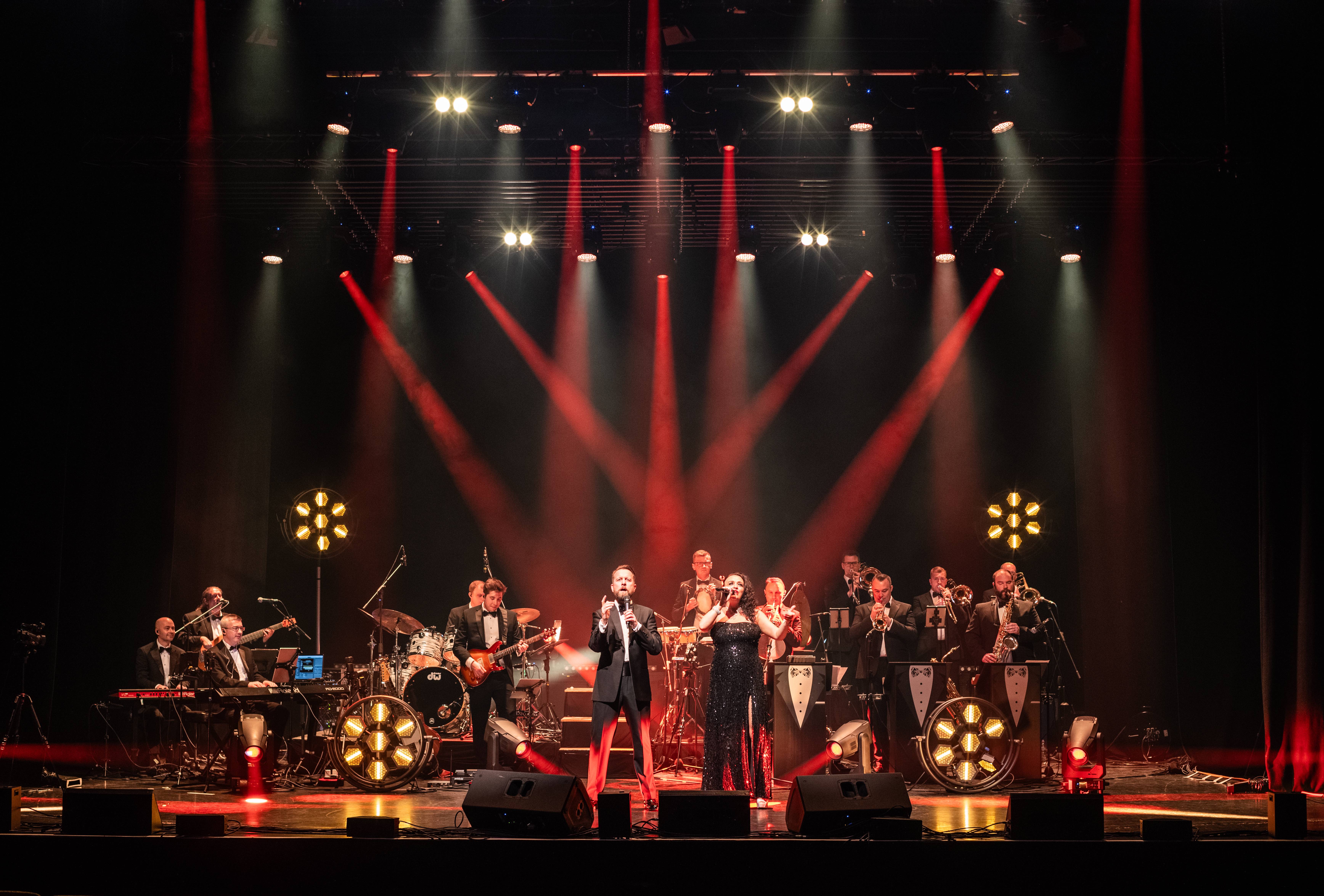 James Bond Themed Concert Spectacular featuring singers and a band on a theatre stage