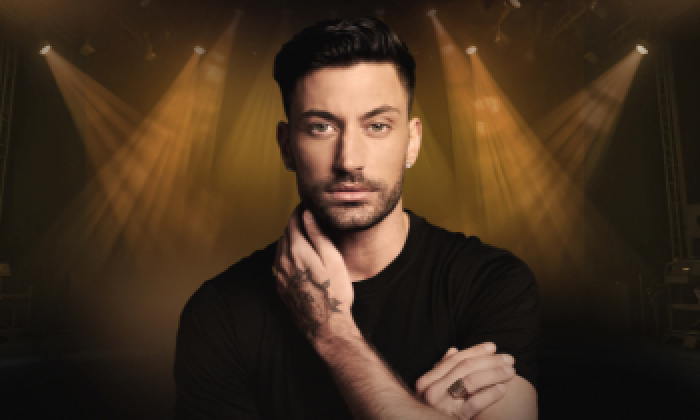 Promotional banner for Giovanni Pernice show Unstoppable which will be on stage at The Victoria Theatre Halifax. The image features Giovanni Pernice being lit by theatre spotlights for his theatre show
